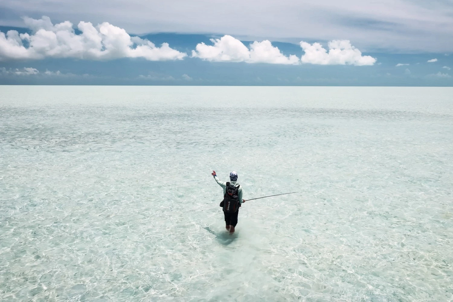 a person standing in water with a pole