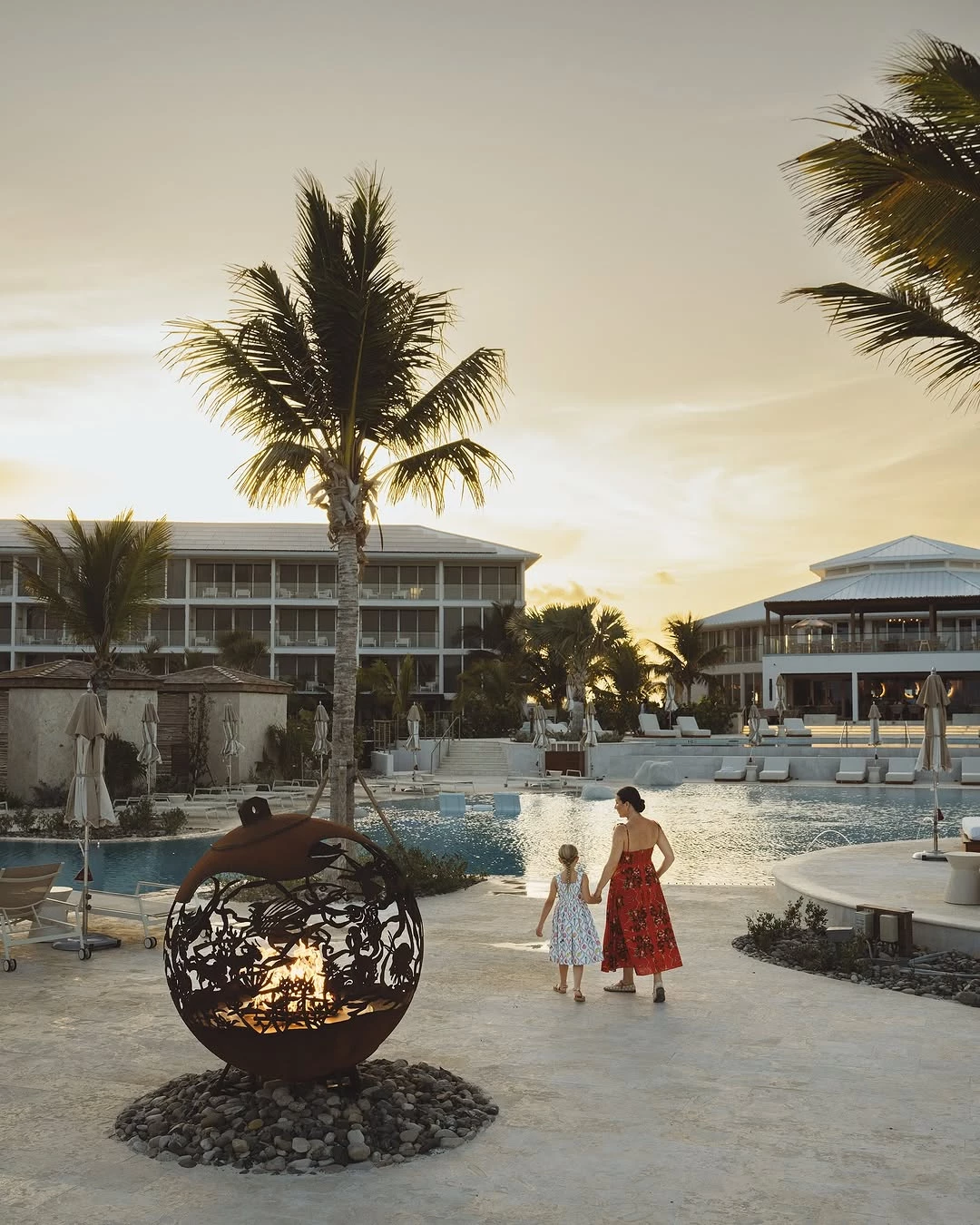 a woman and a girl walking by a pool