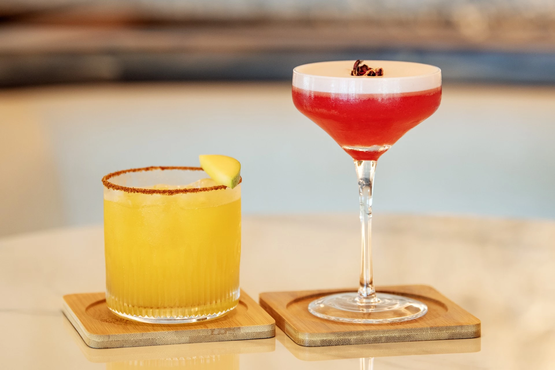 two drinks on coasters on a table