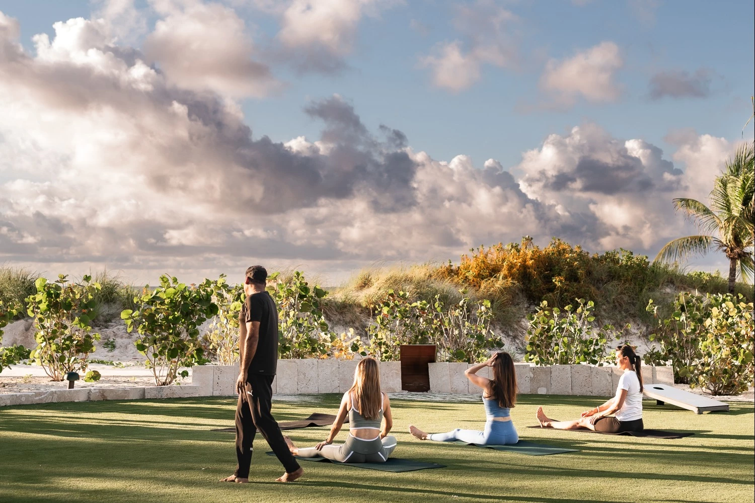 a group of people sitting on grass doing yoga
