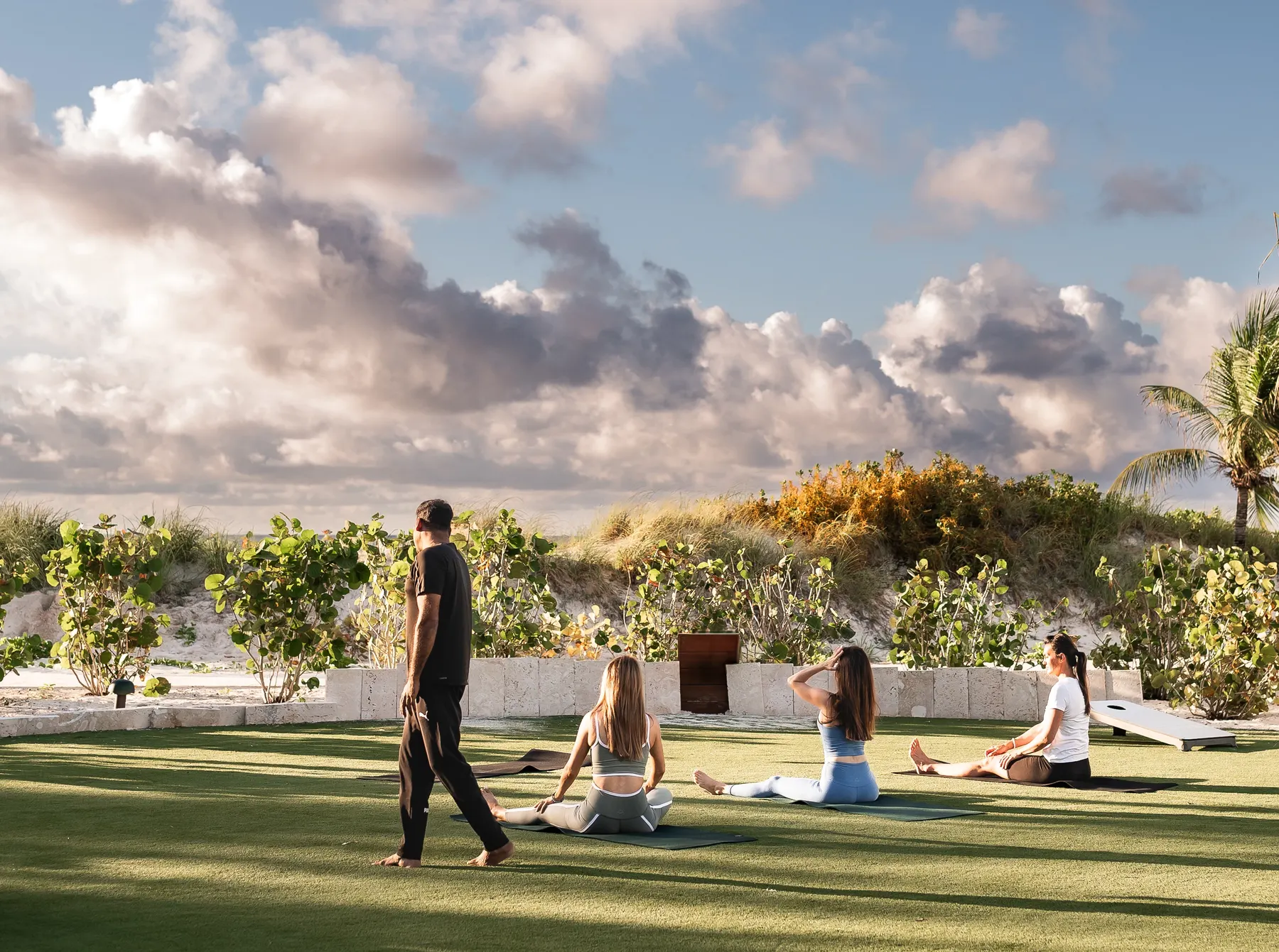 a group of people sitting on grass doing yoga