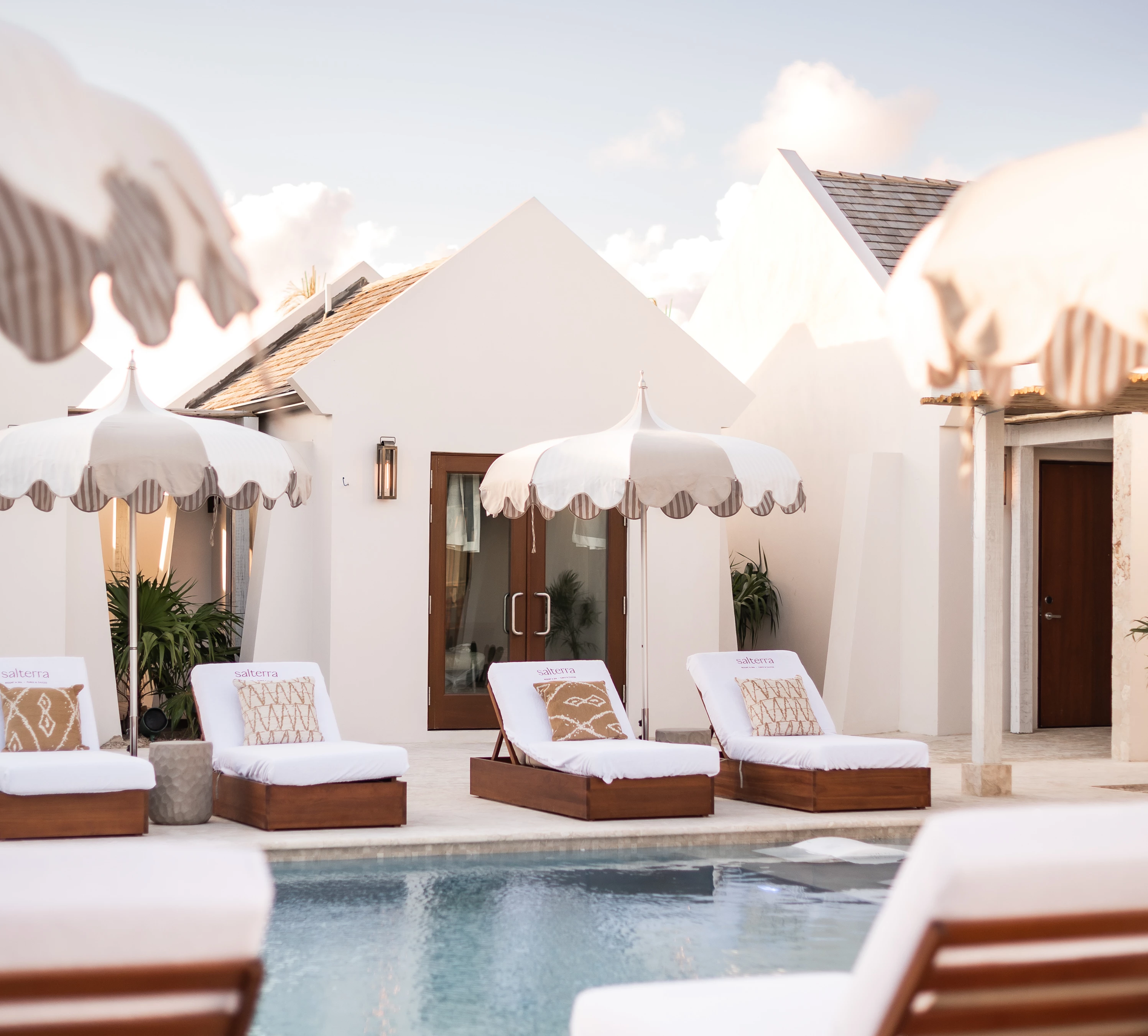 a pool with lounge chairs and umbrellas