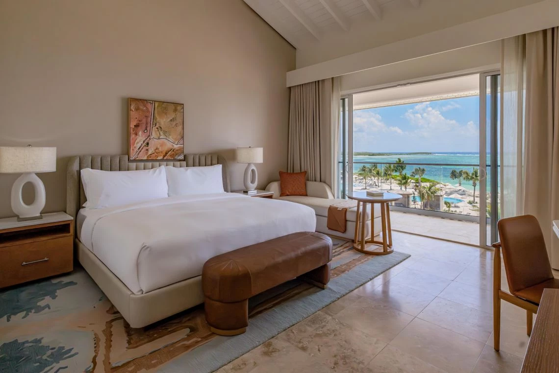 a room with a bed and a window overlooking the ocean