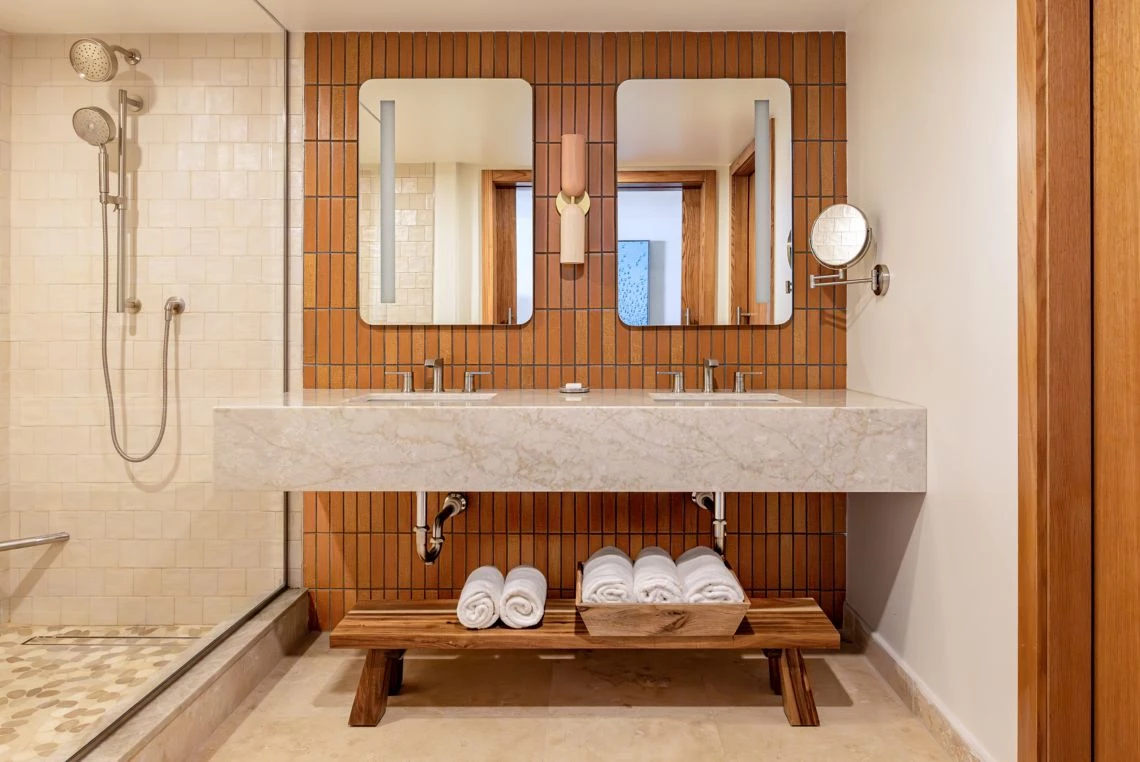 a bathroom with a double sink and two mirrors