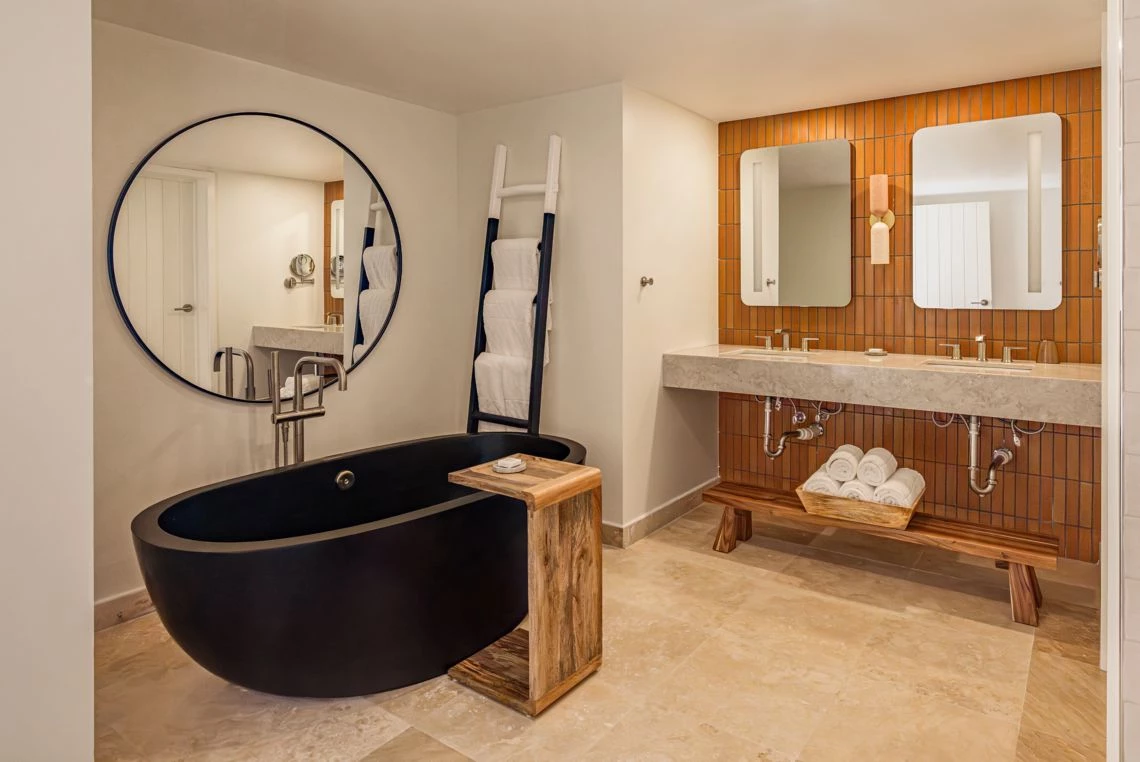 a bathroom with a black tub and a mirror