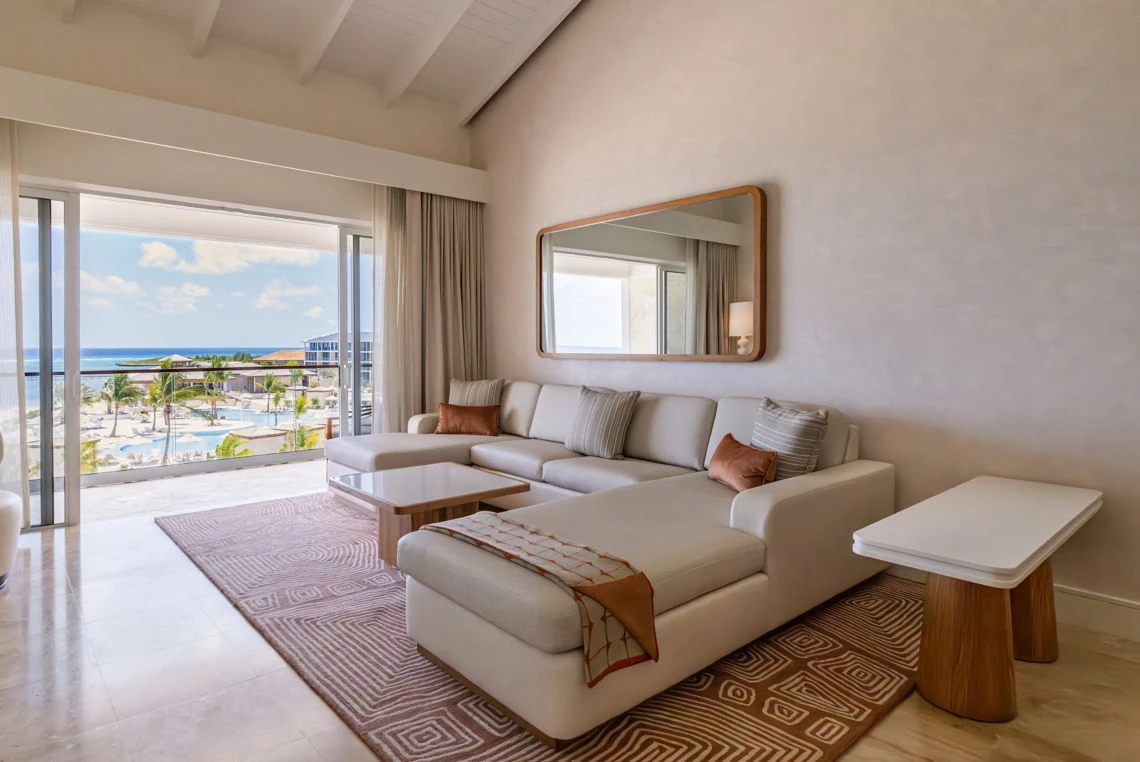 a living room with a large couch and a mirror