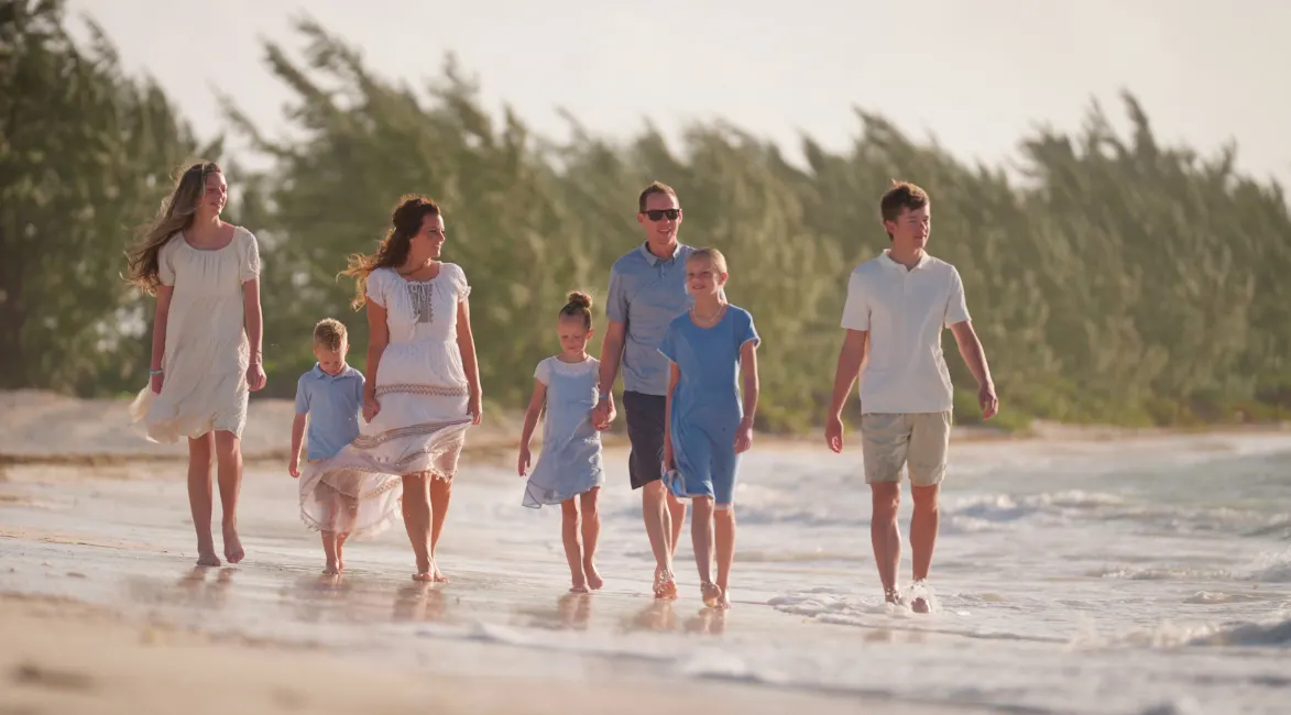 a group of people walking on a beach