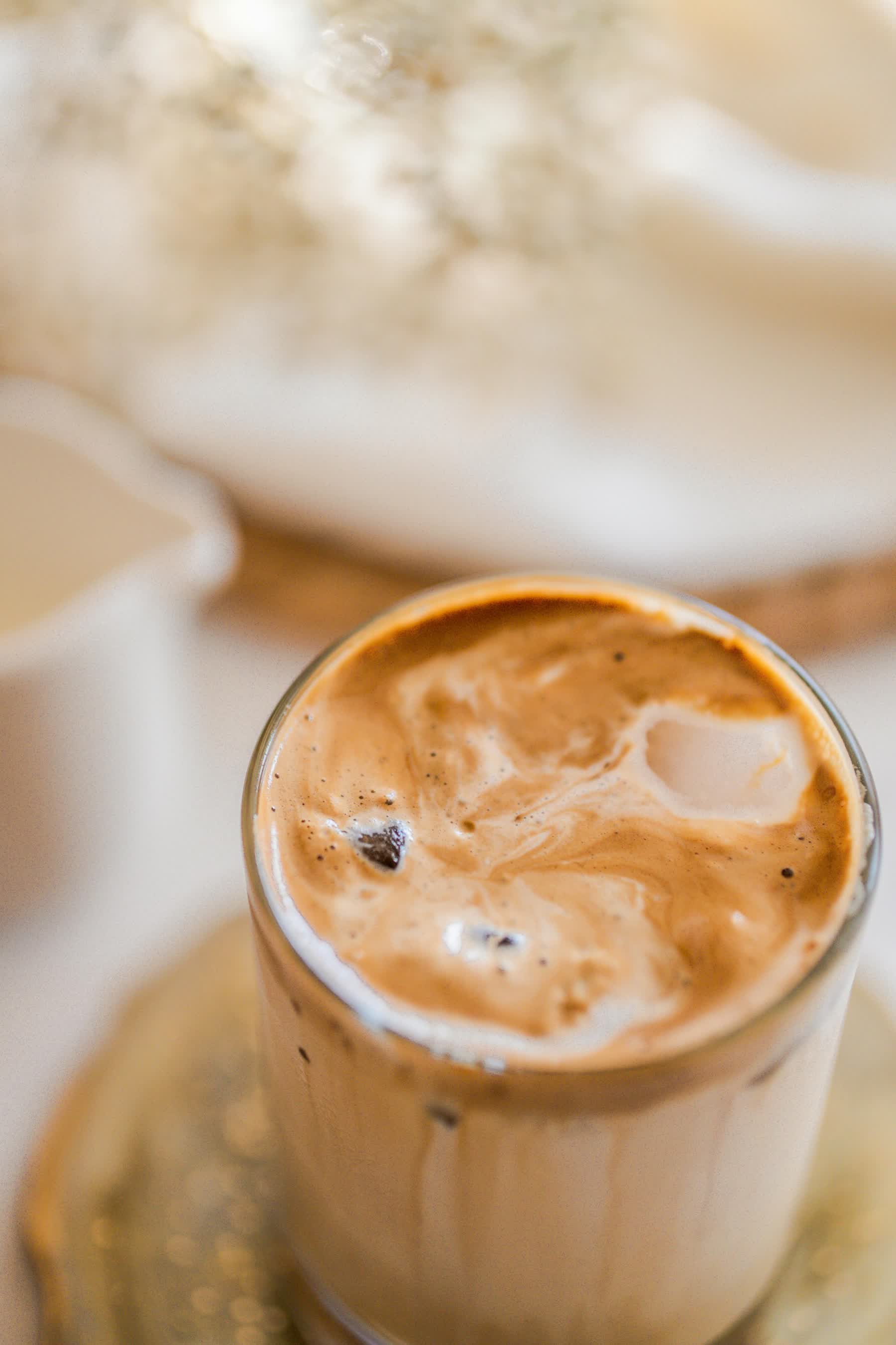 a glass of coffee with ice in it