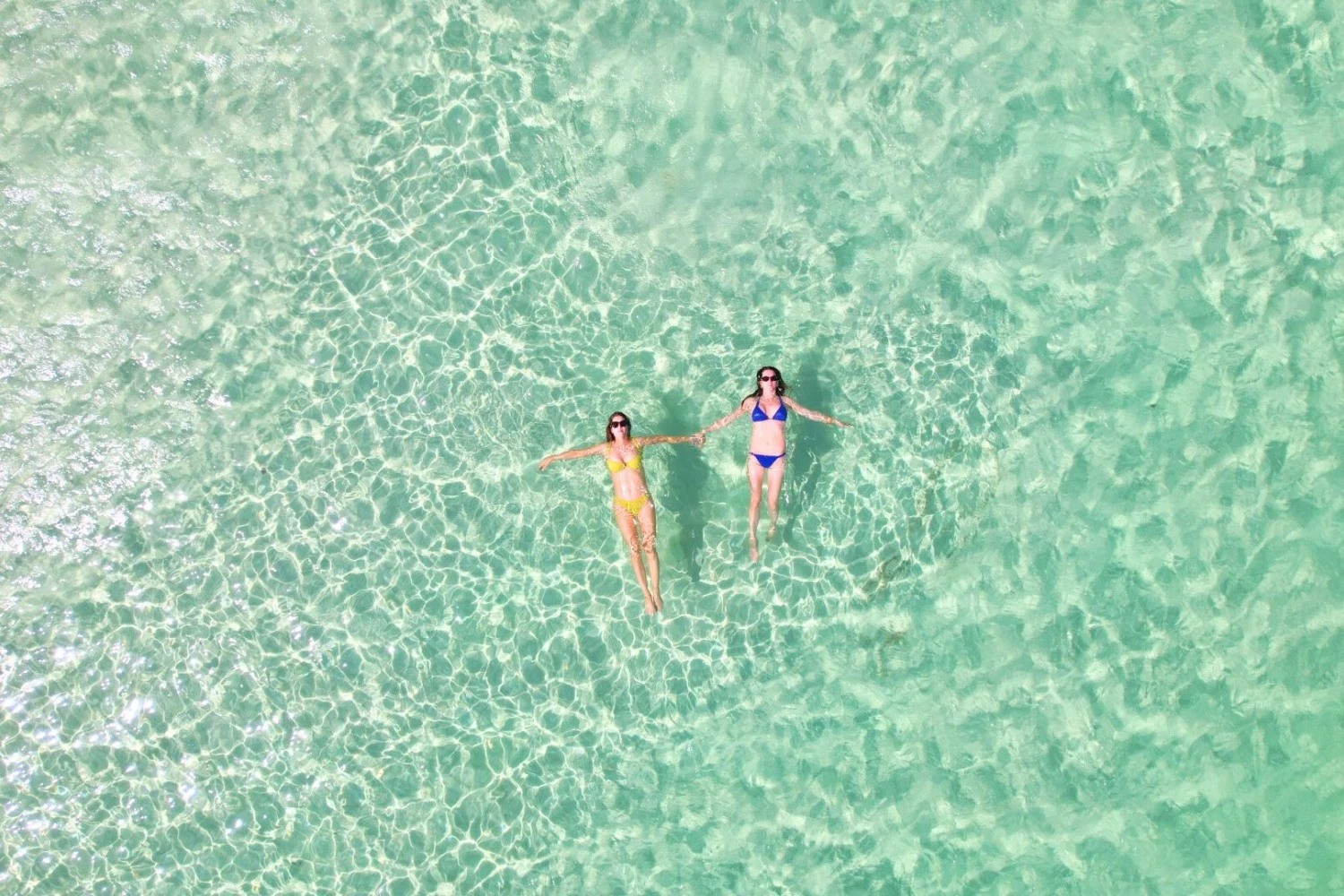 two women in garments floating in clear water