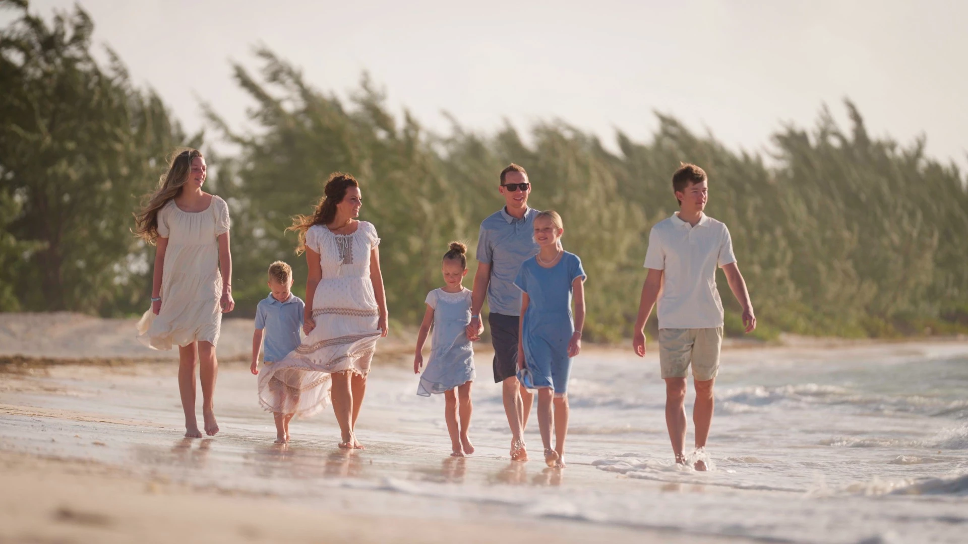 a group of people walking on a beach