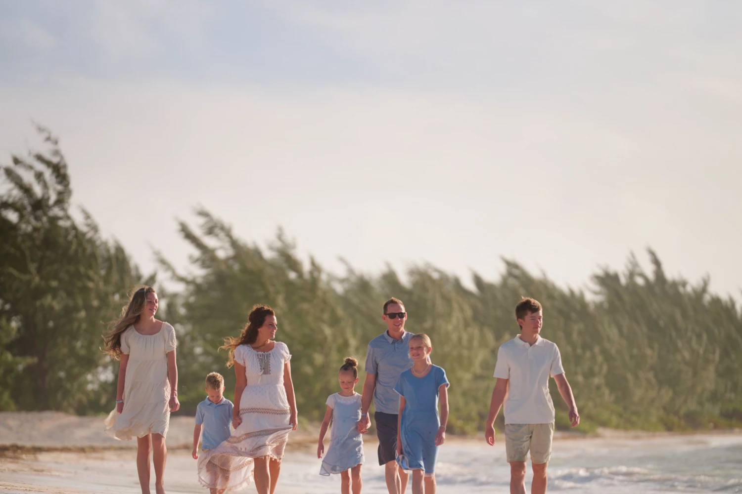 a group of people walking on a beach