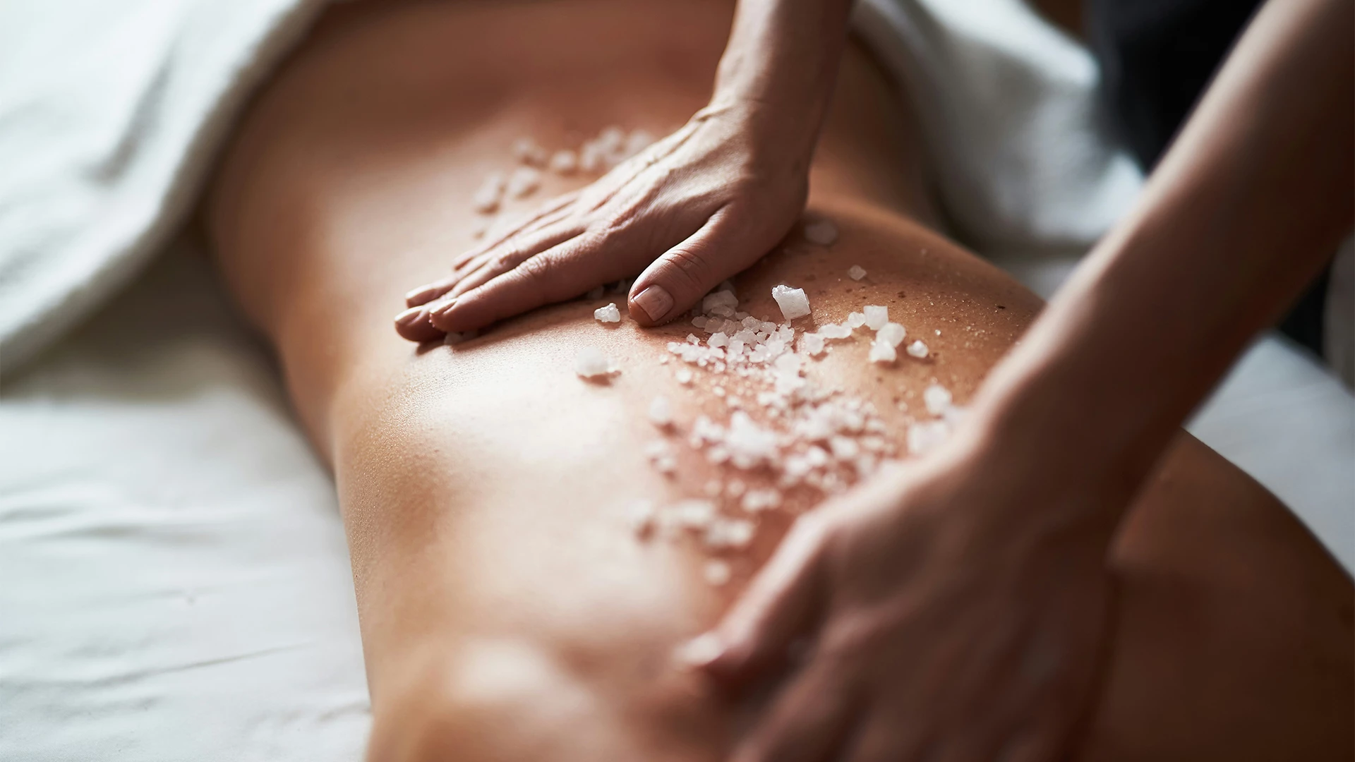 a person's hands massaging a body