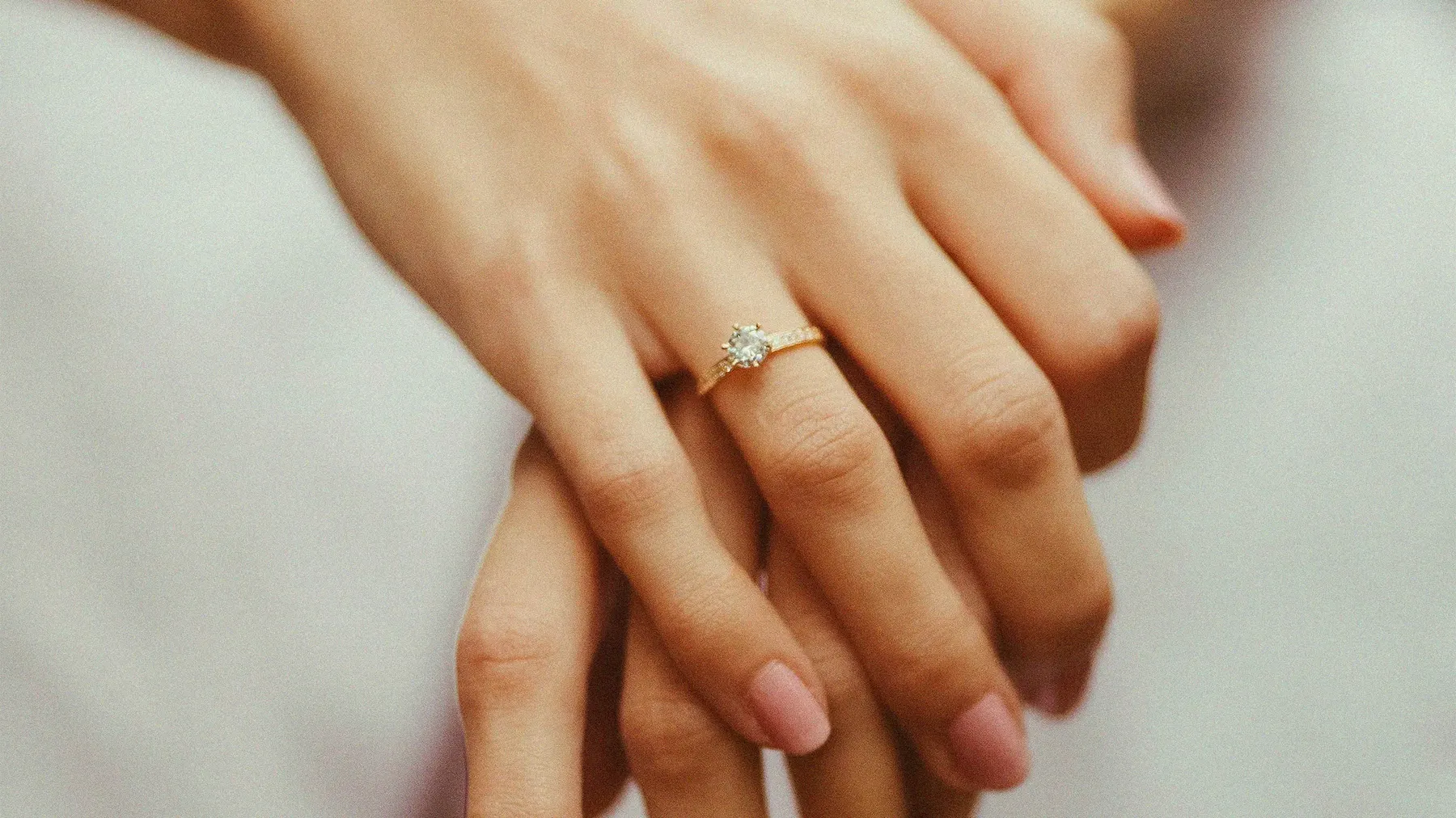 a person's hands with a ring on their finger