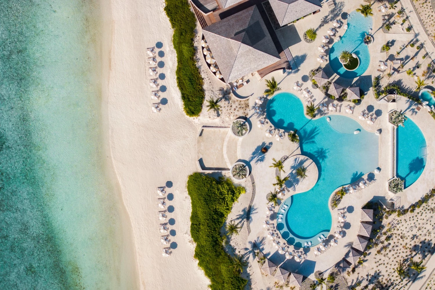 an aerial view of a resort with a pool and a beach