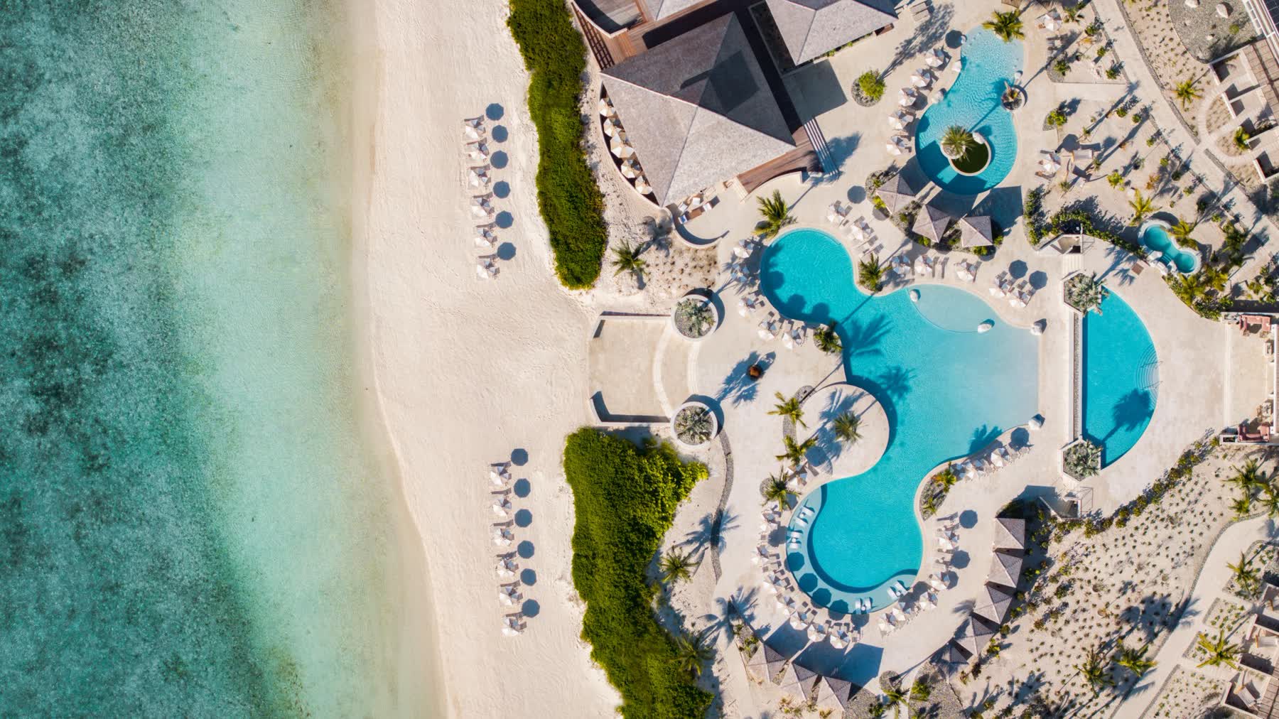 an aerial view of a resort with a pool and a beach