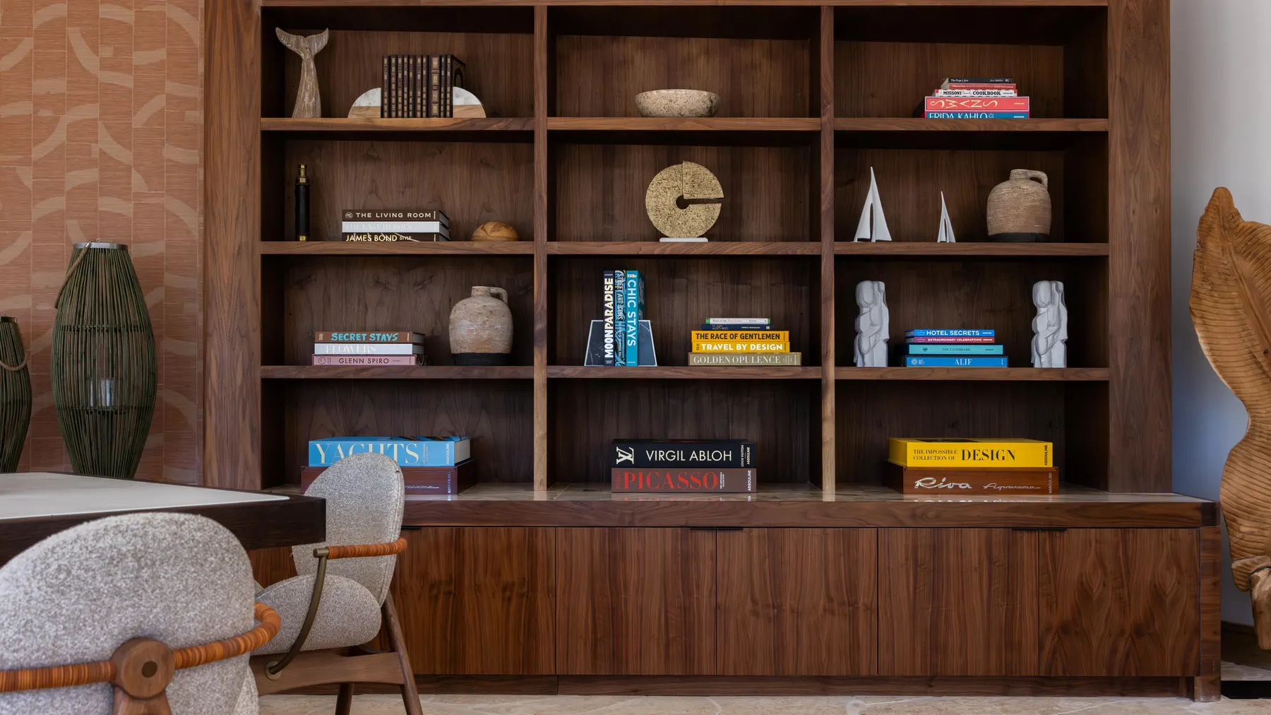 Assouline bookcase with books and a chair