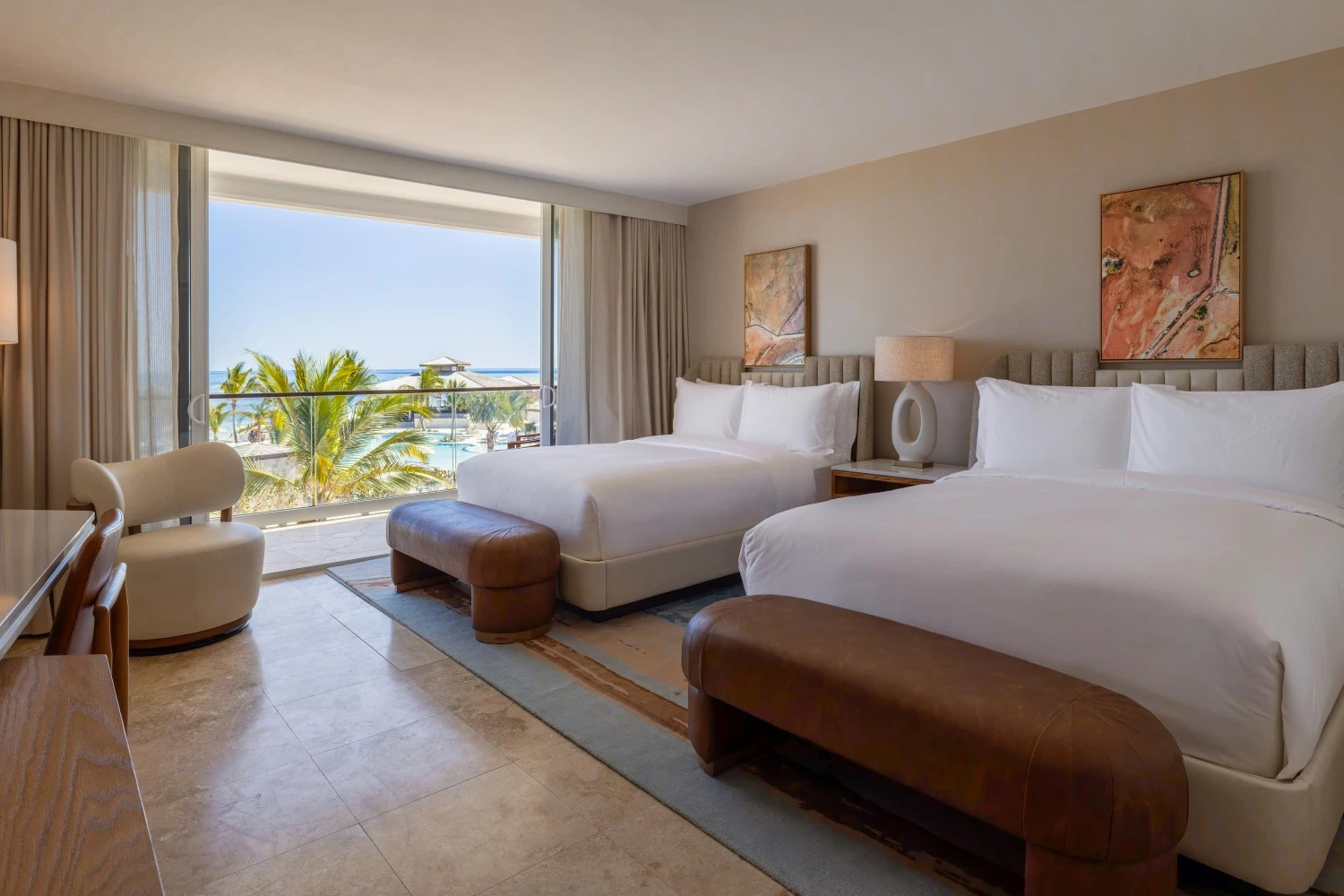 a room with two beds and a large window