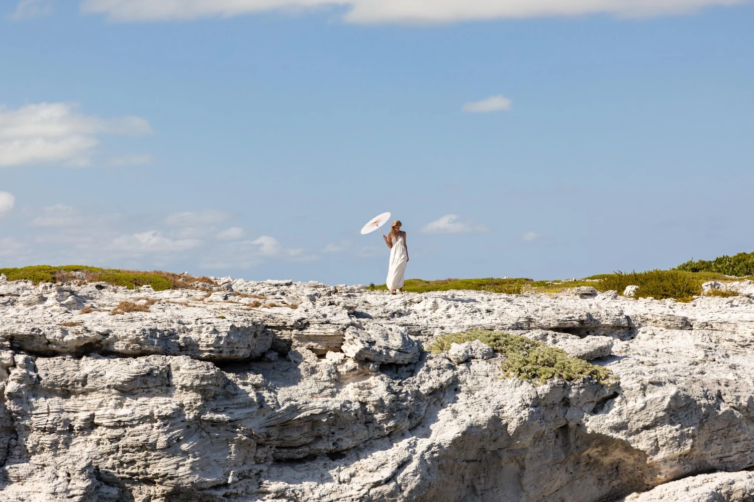 a woman standing on a rocky cliff