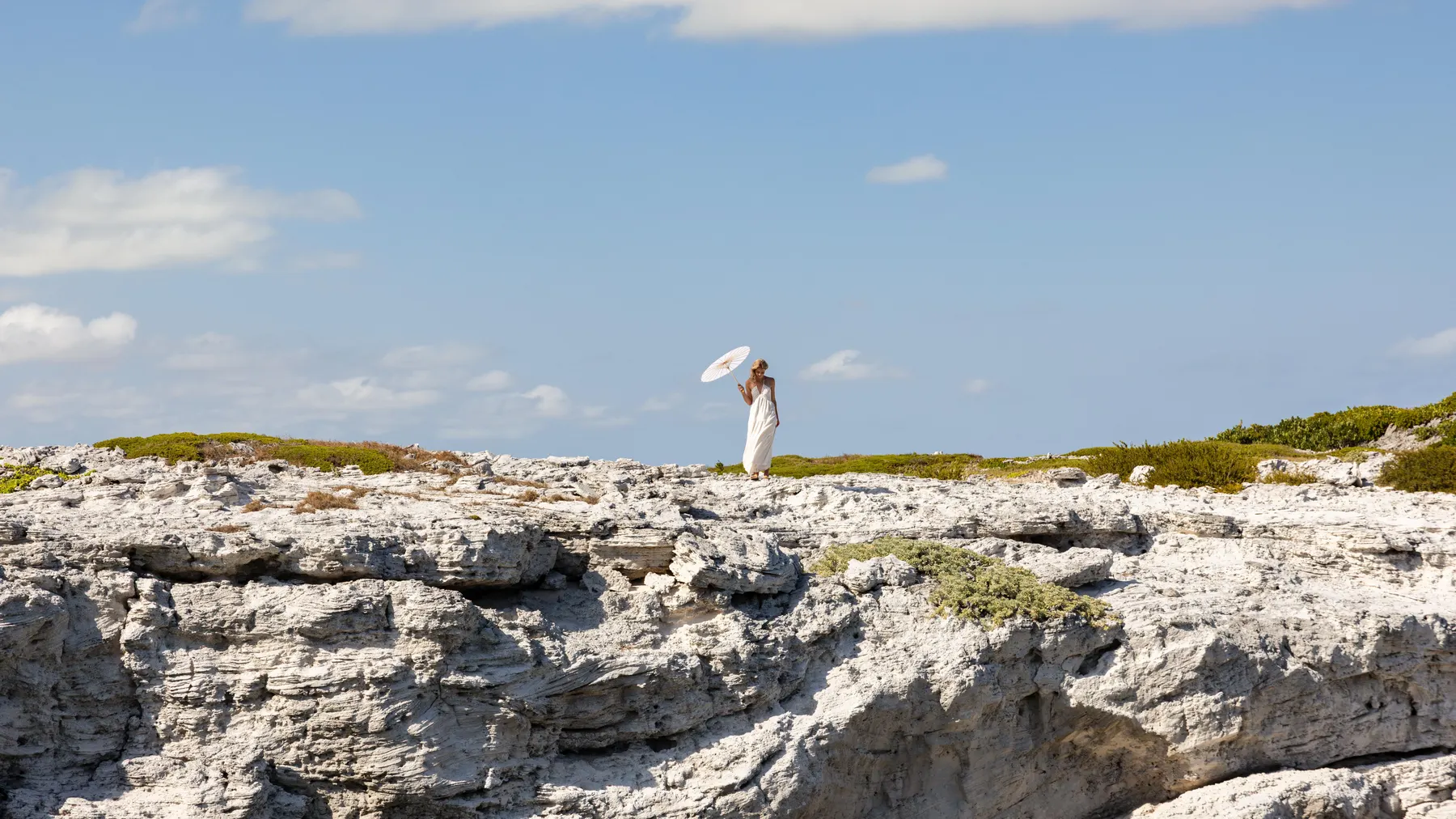 a woman standing on a rocky cliff
