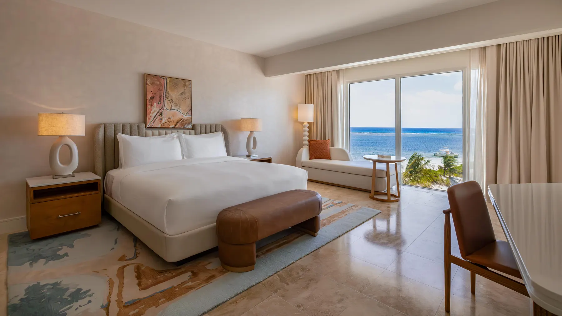 a room with a bed and a couch and a view of the ocean